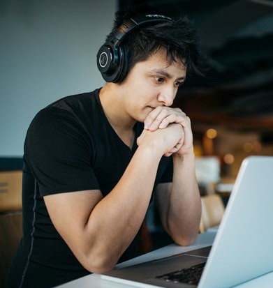 man at computer with headphones on