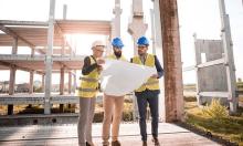 architect/engineers on building site looking at drawing